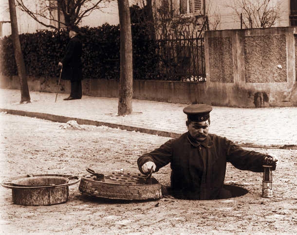 Historisches Bild -  Kanalarbeiter beim Abstieg in die Kanalisation